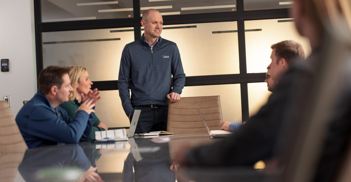 Meeting of JDH employees in the boardroom, lead by CEO, Jeff Hillman