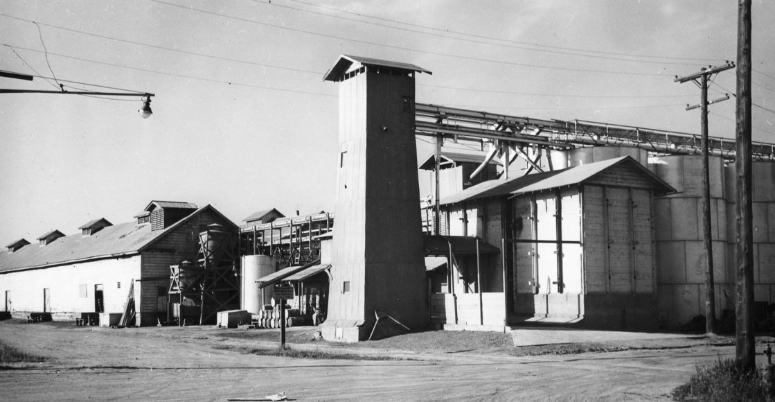 Black and white photo of a JDH feed mill in the 1960s