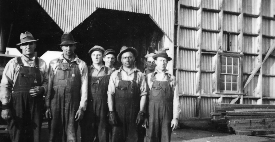 Old photo of gin workers in front of the gin in 1935