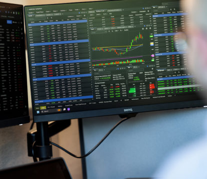 JDH employee working on monitors with market calculations on the screens