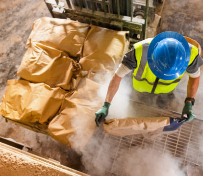 JDH employee adding a bag of ingredients to mixer